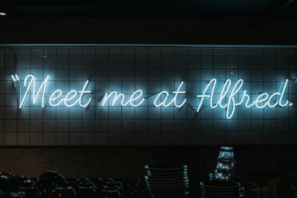 neon sign 'Meet me at Alfred'